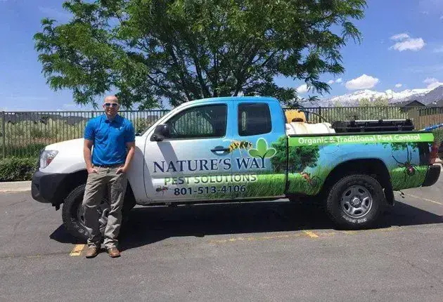 Cade standing beside the wrapped Nature's Way Pest Solutions service truck